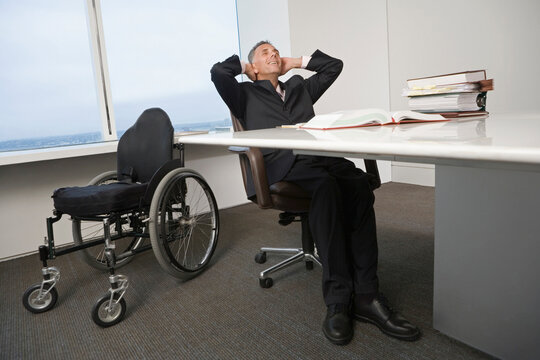 Businessman with a wheelchair relaxing in office