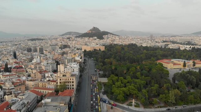 Aerial drone video of  Plaka district, Lycabettus Hill, Vasilissis Amalias Avenue in Athens, near Acropolis and Parthenon Acropolis hill, Plaka picturesque district below, Athens historic centre, Atti