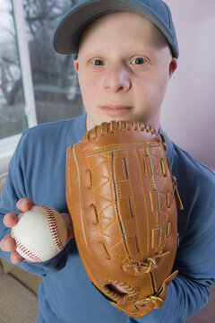 Man with Down Syndrome with a baseball glove and a baseball