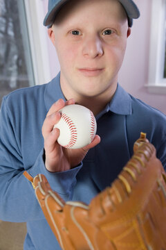 Man with Down Syndrome with a baseball glove and a baseball