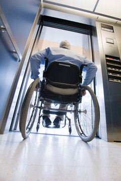 University professor with Muscular Dystrophy in a wheelchair entering an elevator