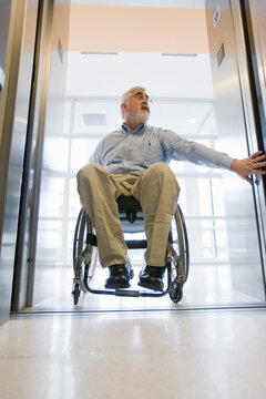 University professor with Muscular Dystrophy in a wheelchair entering an elevator