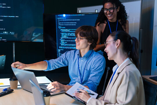 Software engineer team discuss digital project via laptop computer. Tech startup coworker talk about web application database, program code script, and network system in office