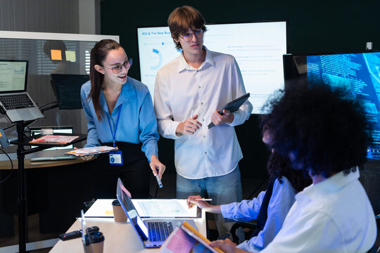 Software engineer team analyze business graph data. Tech startup coworker share web application report, program code milestone, and digital marketing system strategy in office