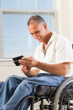 Man with spinal cord injury in wheelchair using a smart phone
