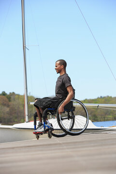 Man in a wheelchair who had Spinal Meningitis at a sailing dock