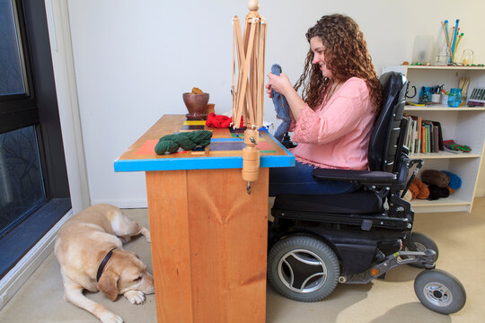 Woman with Muscular Dystrophy working with her yarn for her knitting business