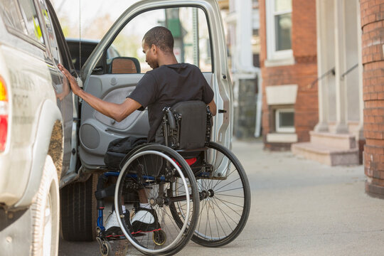Man in a wheelchair who had Spinal Meningitis entering his accessible vehicle
