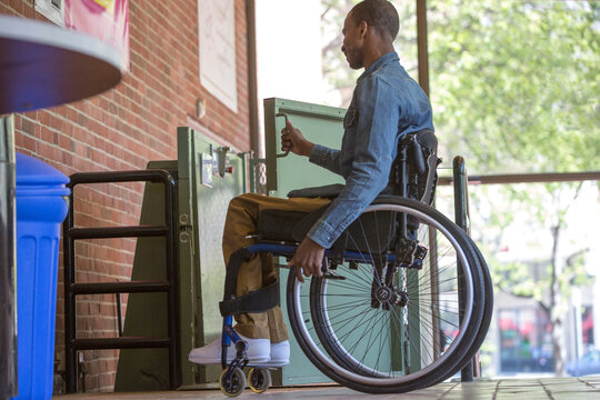 Man who had Spinal Meningitis in a wheelchair using a lift instead of stairs