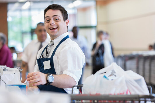 Happy man with Down Syndrome working at a grocery store