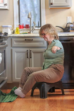 Woman with TAR Syndrome picking up a kitchen towel with her feet