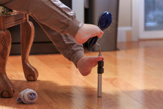 Woman with TAR Syndrome picking up her hair brush with her feet