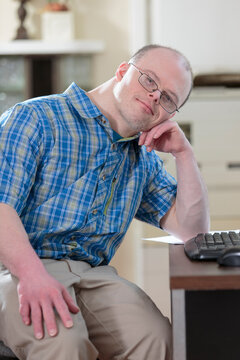 Man with Down Syndrome sitting at his computer in an office