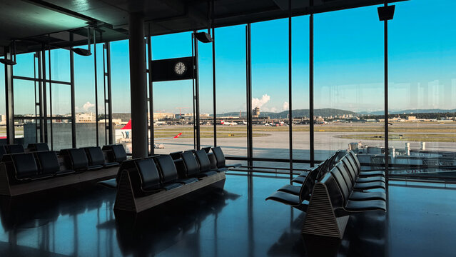 Zurich, Switzerland - May 29, 2025: View of Zurich Airport terminal with seating and runway in clear weather during the day