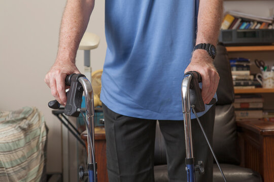 Man with Ataxia holding his walker to use in his bedroom