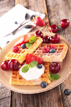 sweet waffles with whipped cream and fresh berries on plate