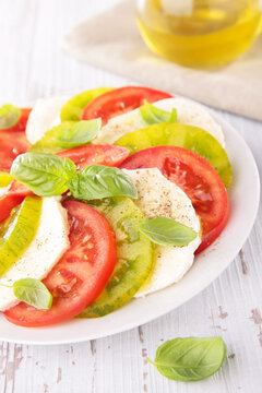 caprese salad with red and green heritage tomatoes and mozzarella
