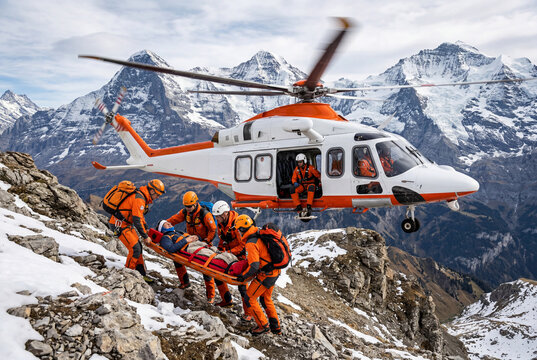 Mountain rescue team assisting an injured person near a helicopter in a remote alpine environment during an emergency mission.