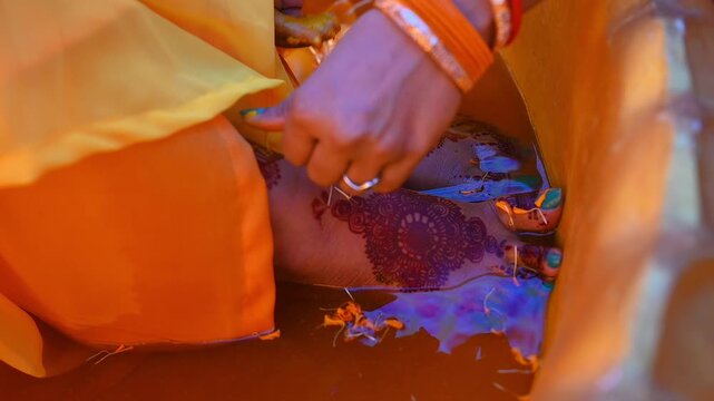 Close-up footage of a traditional Indian Haldi ceremony where family members and friends apply turmeric paste to the bride before marriage. The pre-wedding ritual symbolizes purification, blessings.