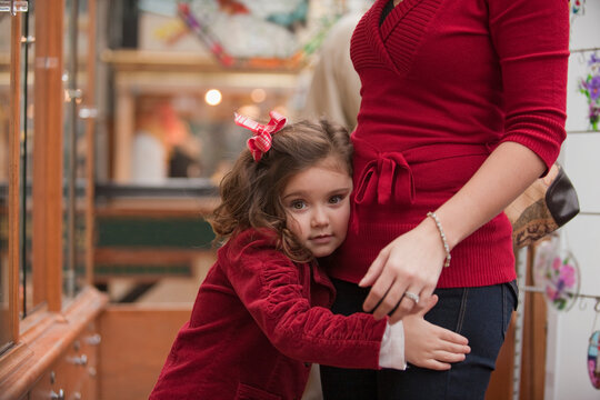 Young girl clinging to her mother