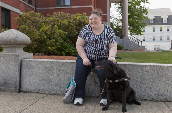 Woman with Visual Impairment sitting on a curb with her service dog