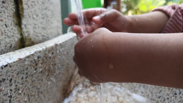 washing hands at a sink with running water, demonstrating proper hygiene practices to support cleanliness and disease prevention.