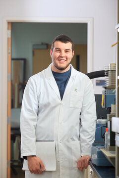 Engineering student holding user manual for chemical analysis instrument in chemical analysis