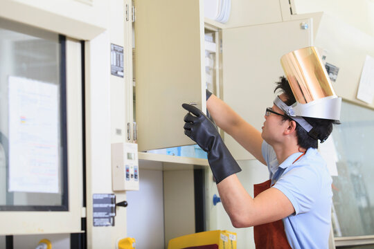 Engineering student with protective equipment looking for supplies in a chemistry laboratory