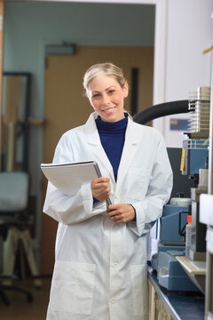 Engineering student holding user manual for chemical analysis instrument in chemical analysis