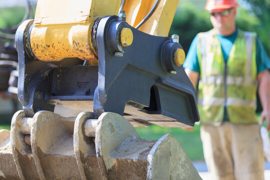 Construction worker watching excavator bucket