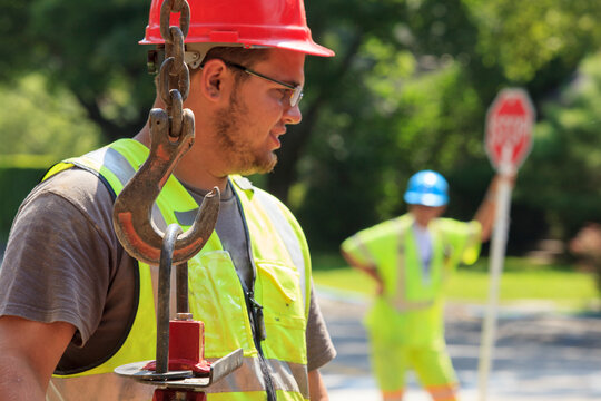 Construction worker moving gate valve on street