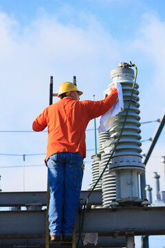 Power engineer cleaning a fluid filled high voltage insulator