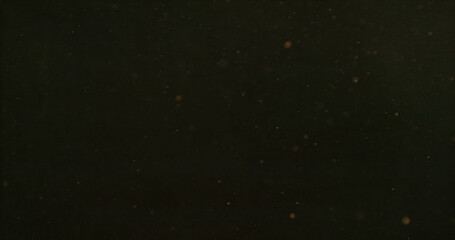 Fototapeta premium Golden dust particles suspended in the air forming an atmospheric cloud. Cinematic abstract texture perfect for overlays, visual effects, motion graphics and creative compositing projects.