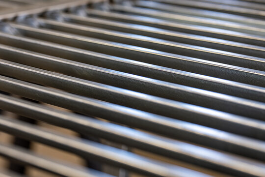 Barres m&eacute;talliques horizontales formant un fond textur&eacute; avec reliefs, cr&eacute;ant une surface industrielle graphique et moderne.