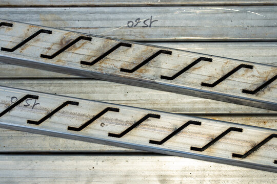 Composition abstraite de lames m&eacute;talliques d&eacute;coup&eacute;es en forme ondul&eacute;e.