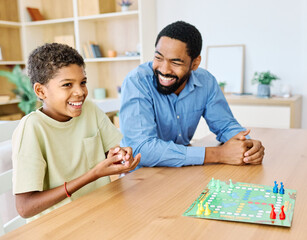 Fototapeta premium Portrait of a happy african american family at home, having fun playing a board game challenge game, playing board game ludo at home