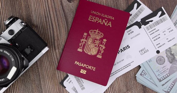 Beautiful overhead layout of spanish passport document combined with boarding pass airplane tickets over a dark wooden office desk