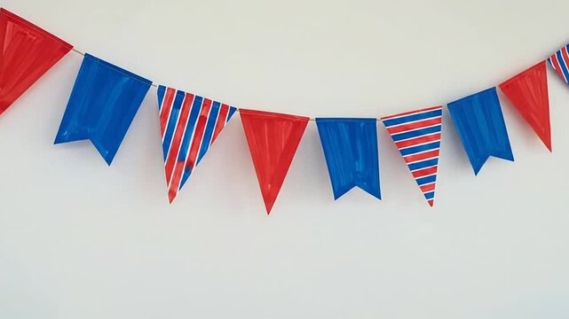 Red and blue triangular bunting flags on white wall.