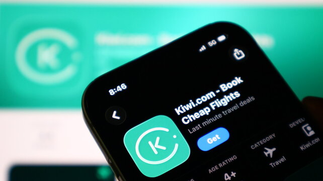 Closeup of a smartphone screen displaying the kiwicom app store page for booking cheap flights and travel deals