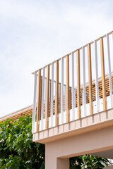 Fototapeta premium Bâtiment moderne avec barrières en bois et poutres blanches, illustrant une architecture contemporaine au design épuré.
