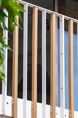 Fototapeta premium Bâtiment moderne avec barrières en bois et poutres blanches, illustrant une architecture contemporaine au design épuré.