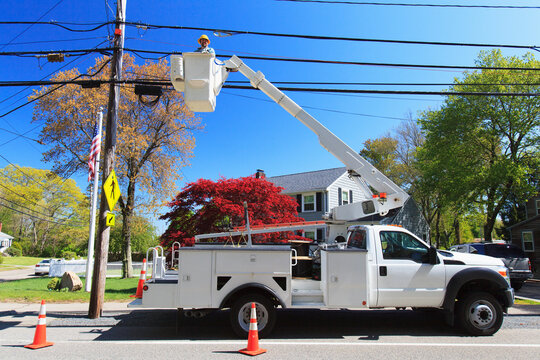Power engineer in lift bucket working on power lines