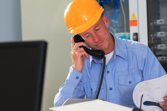 Electrical engineer reviewing process diagrams in operations room of electric power plant