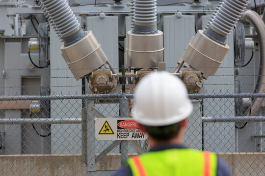 Power engineer looking at high voltage transformer at a power plant
