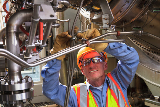 Engineer under ignitor stage of gas turbine which drives generators in power plant while turbine is