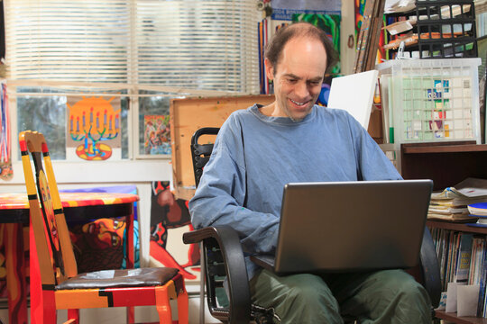Man with Asperger's working on his computer in his art studio