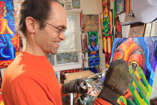 Man with Asperger's painting in his art studio