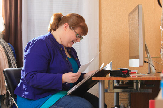 Woman who is legally blind reviewing her job applications in her home
