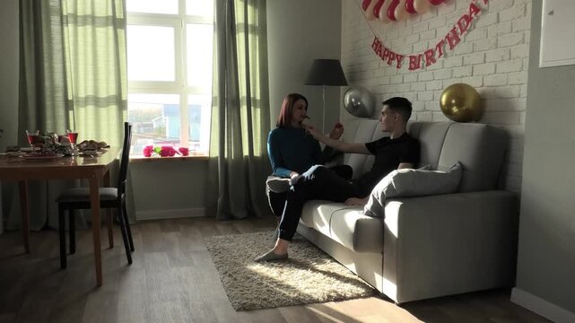 Son jokingly tries on decorative moustache on his mother