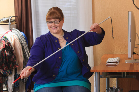 Woman who is legally blind preparing her cane to use in her house
